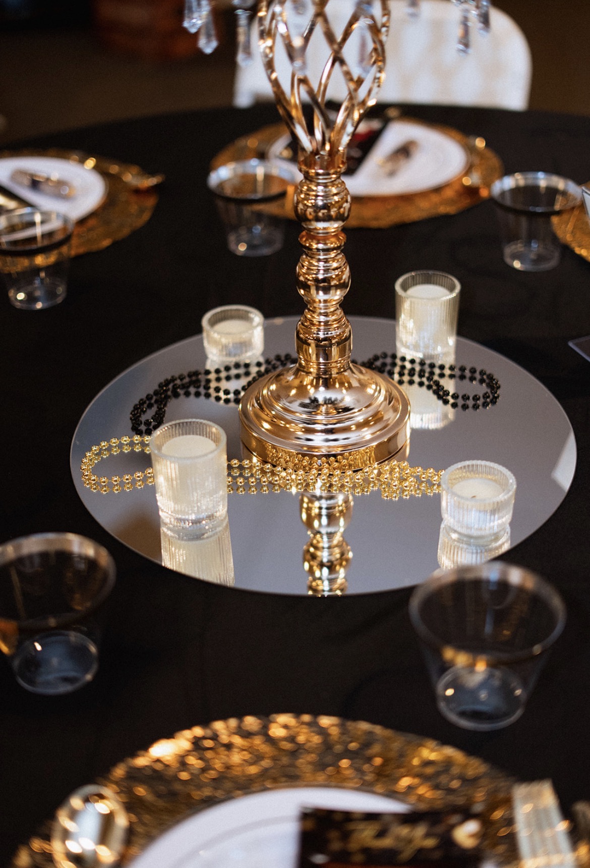 Glam black and gold centerpiece with candelabra on mirror tray